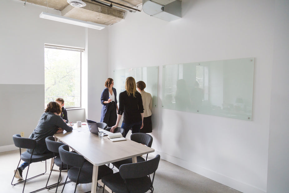 Agile team brainstorming around conference table with laptops
